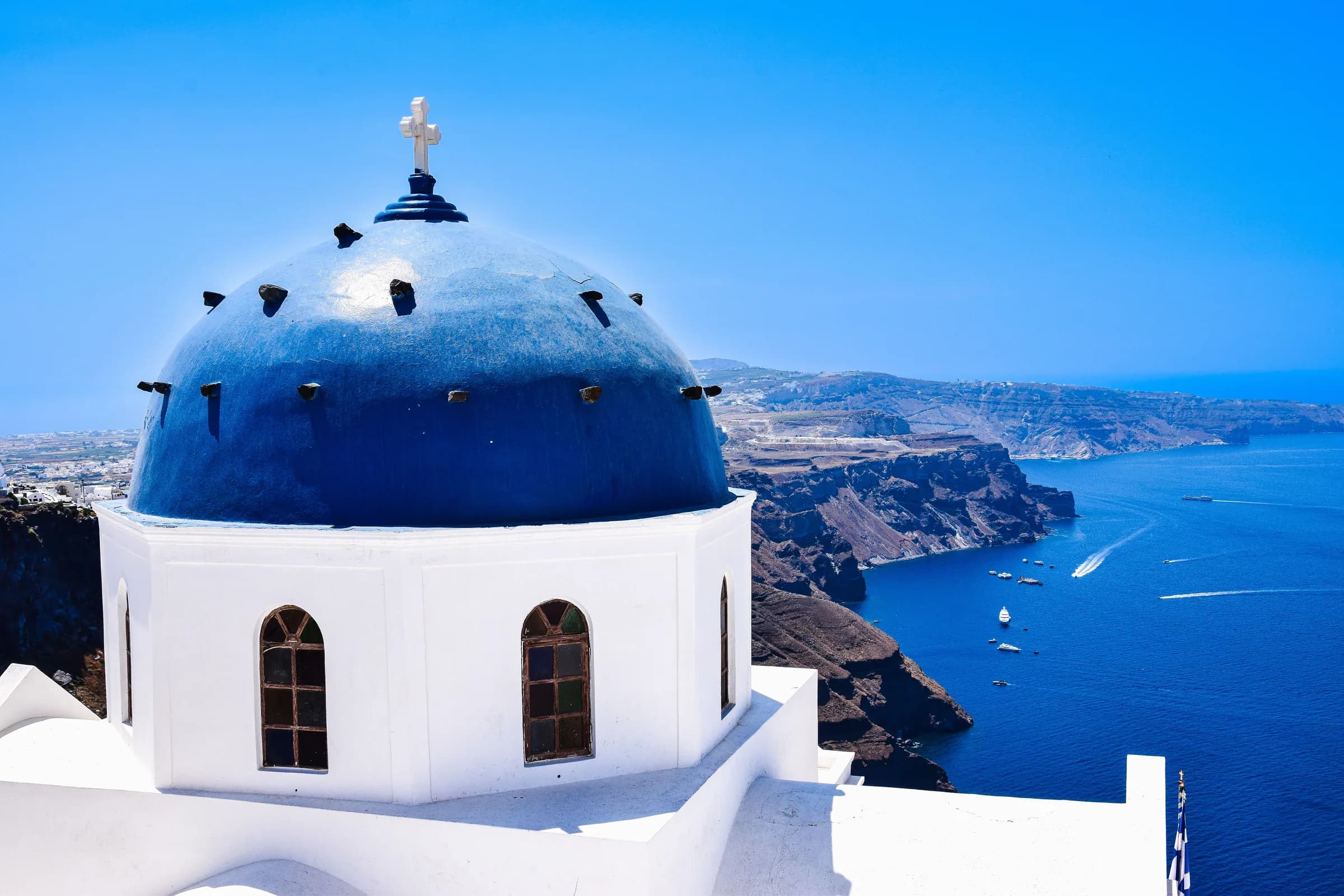 Blue-domed church above the Aegean caldera, Cyclades, Greece