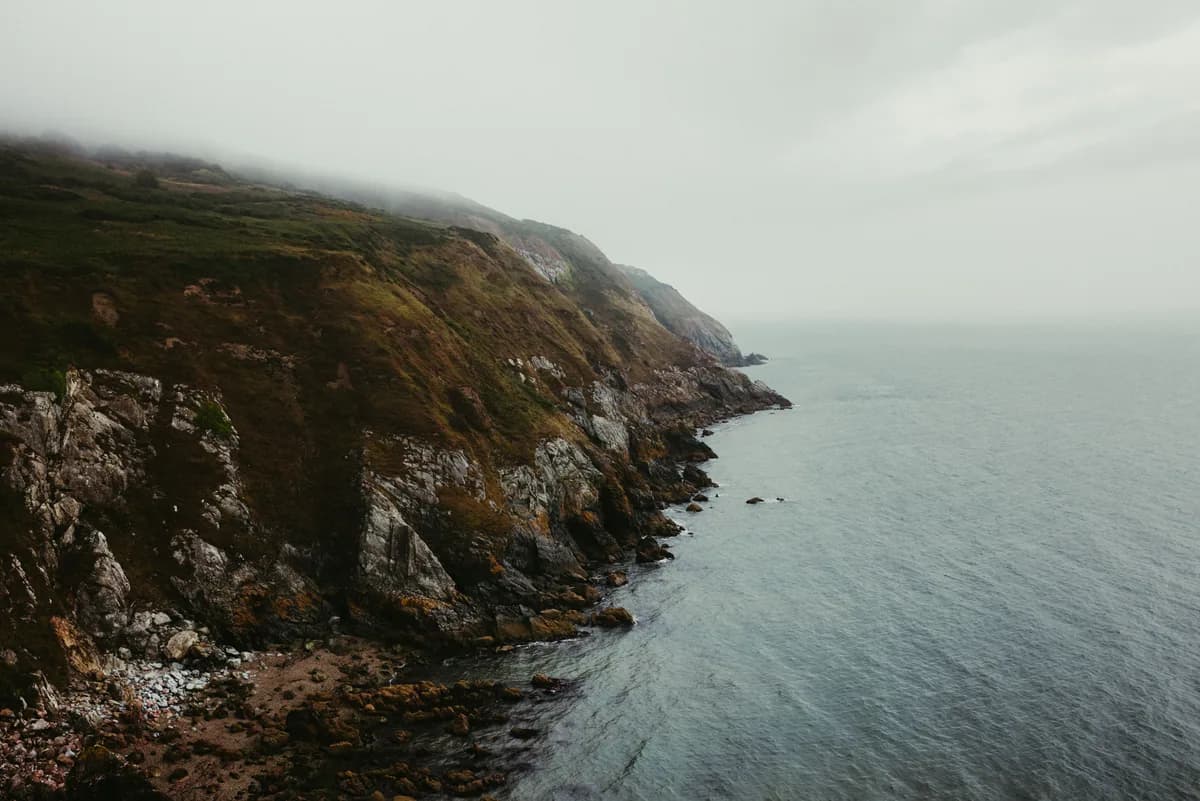 Explore the rocky cliffs of Howth with a misty seaside view in Dublin, Ireland.