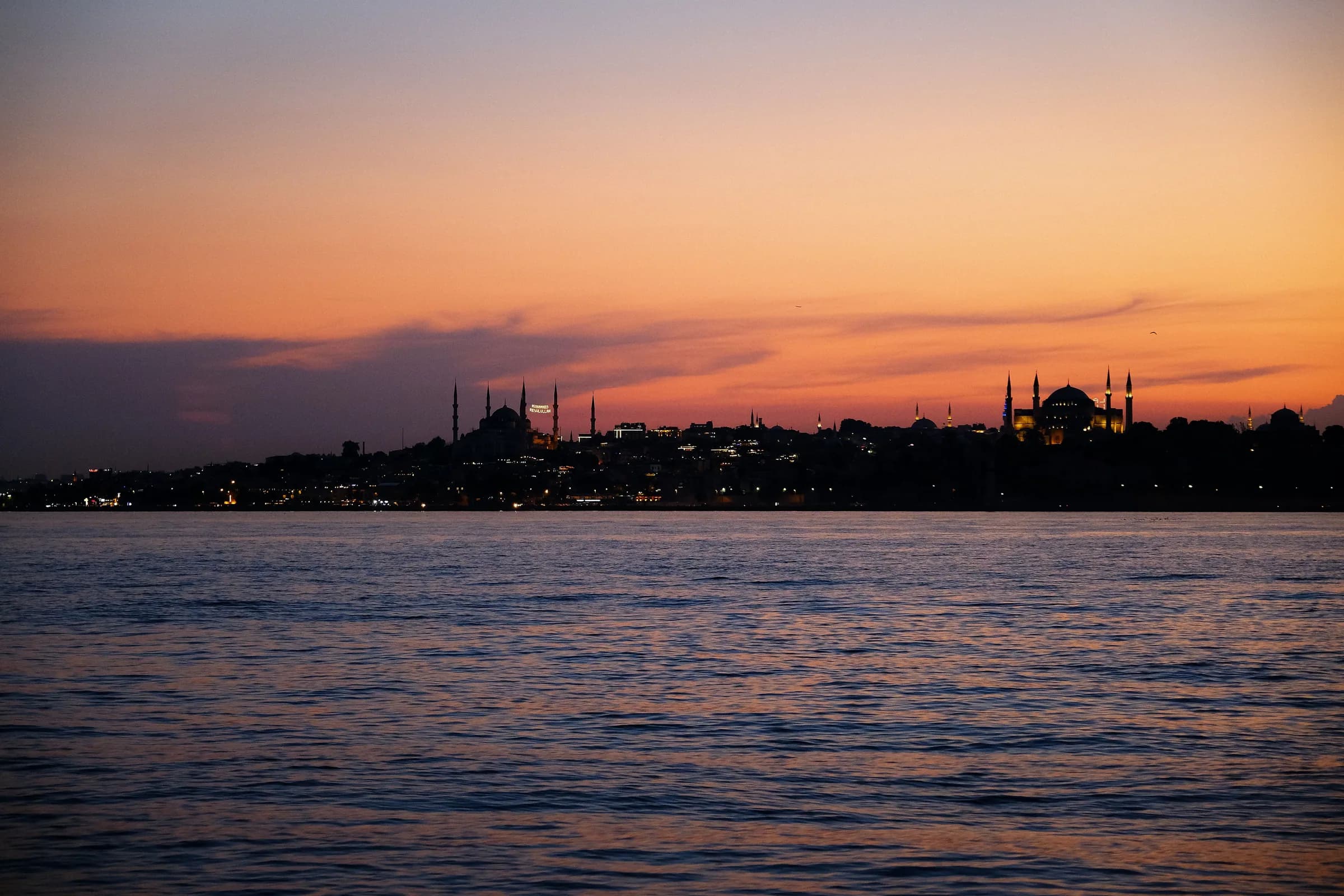 Beautiful Istanbul skyline over water at twilight with mosques in view.