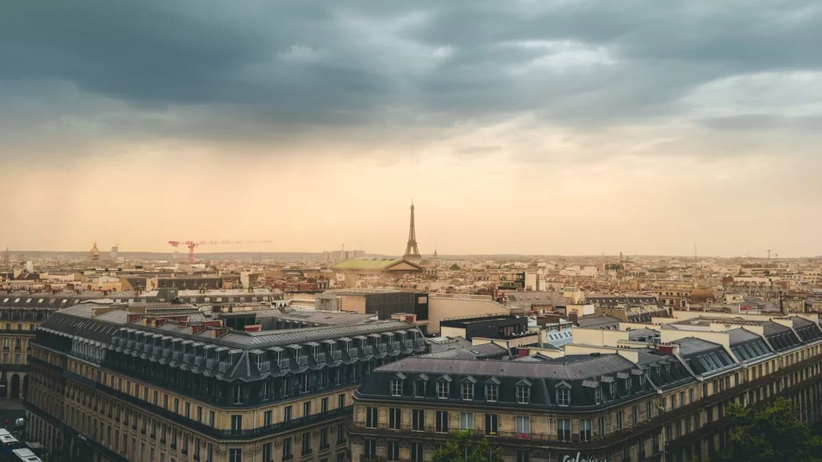 Beautiful view of Paris skyline featuring the Eiffel Tower under dramatic clouds.